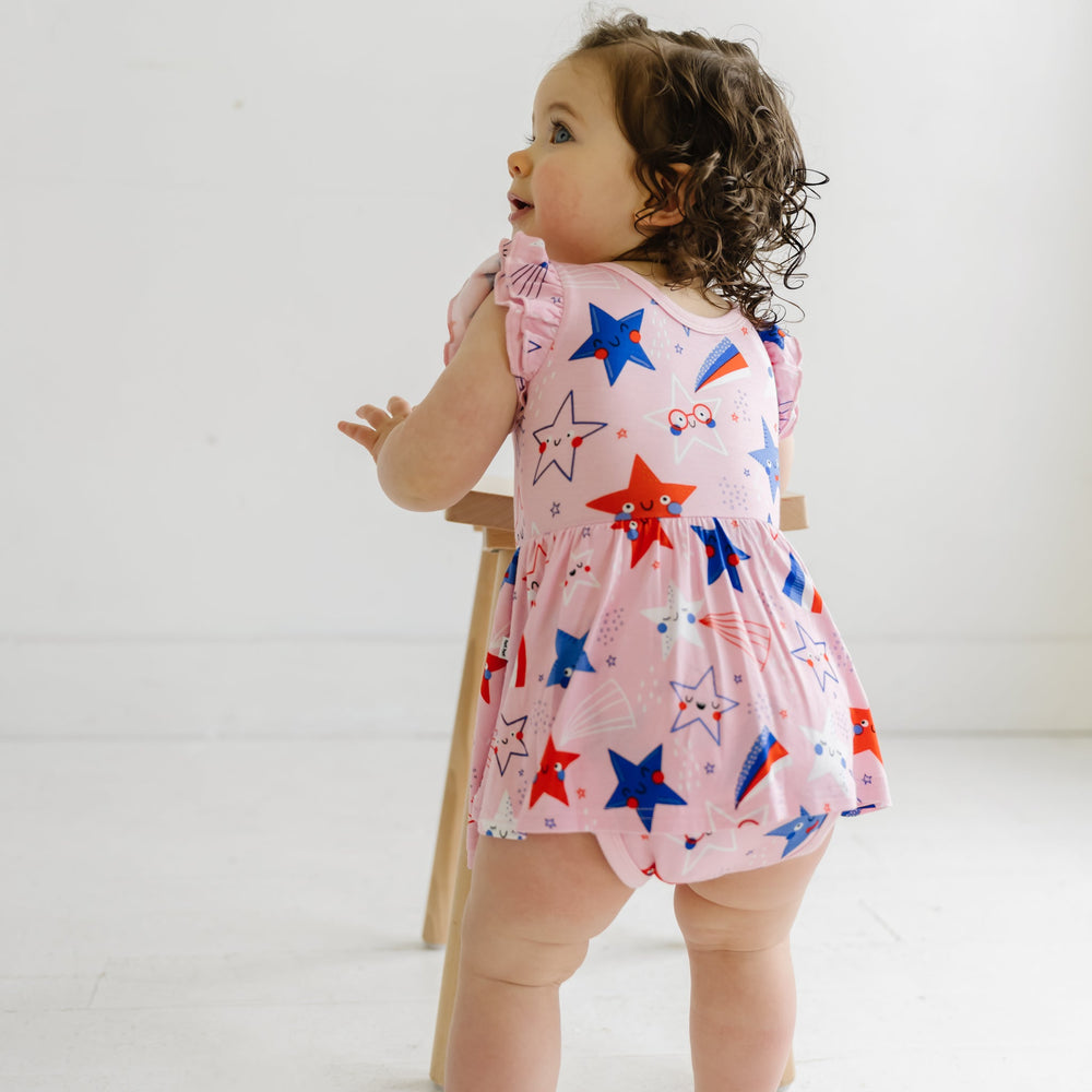 Backside view of a child wearing a Pink Stars and Stripes printed twirl dress with bodysuit
