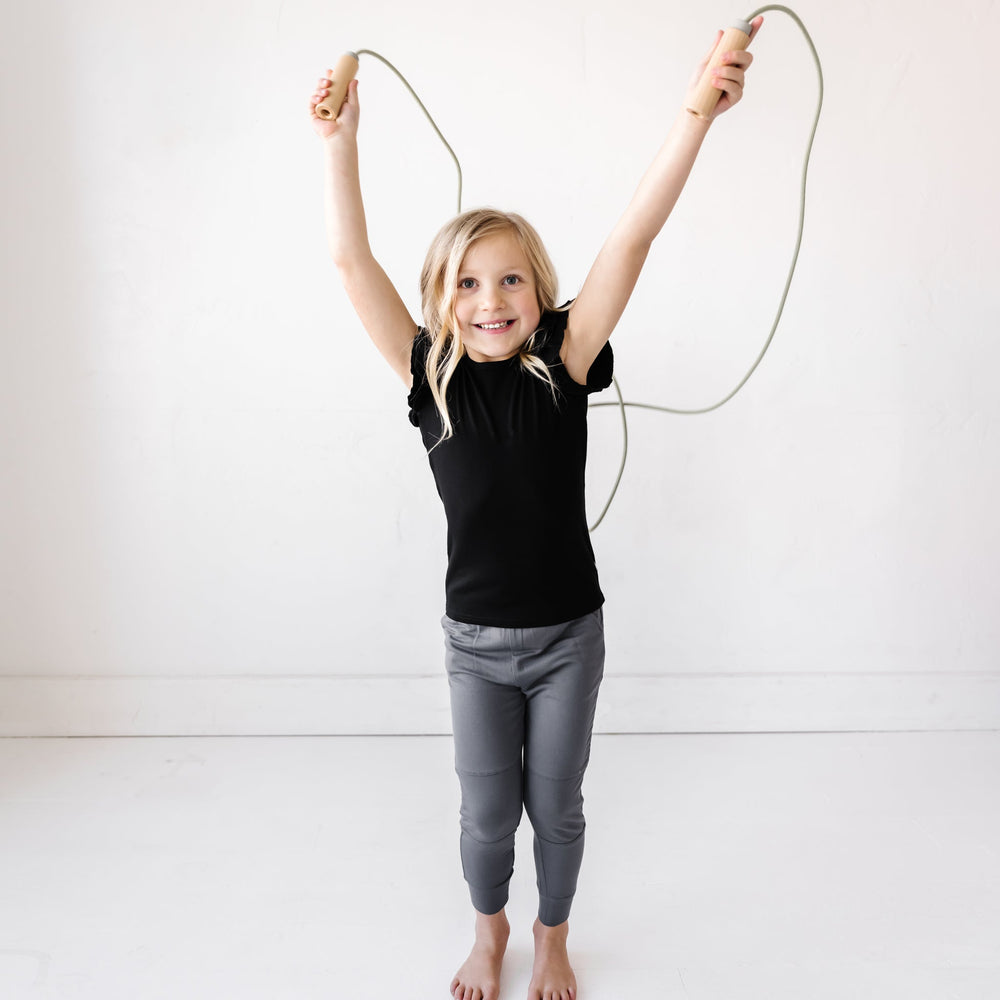 Child in Black Bamboo Viscose Flutter Sleeve Tee and Charcoal Bamboo Viscose Joggers from Play by Little Sleepies