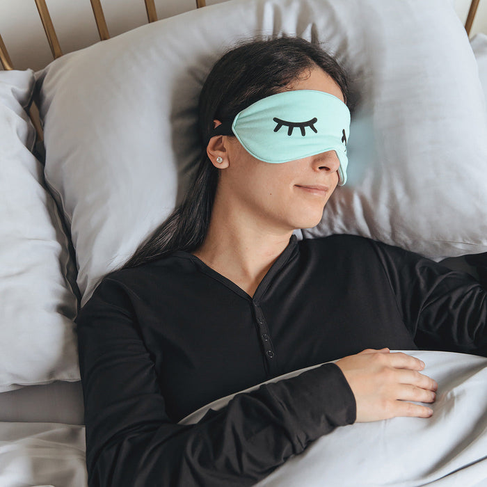 Woman sleeping in bed wearing an Adult Aquamarine Bamboo Sleep Mask