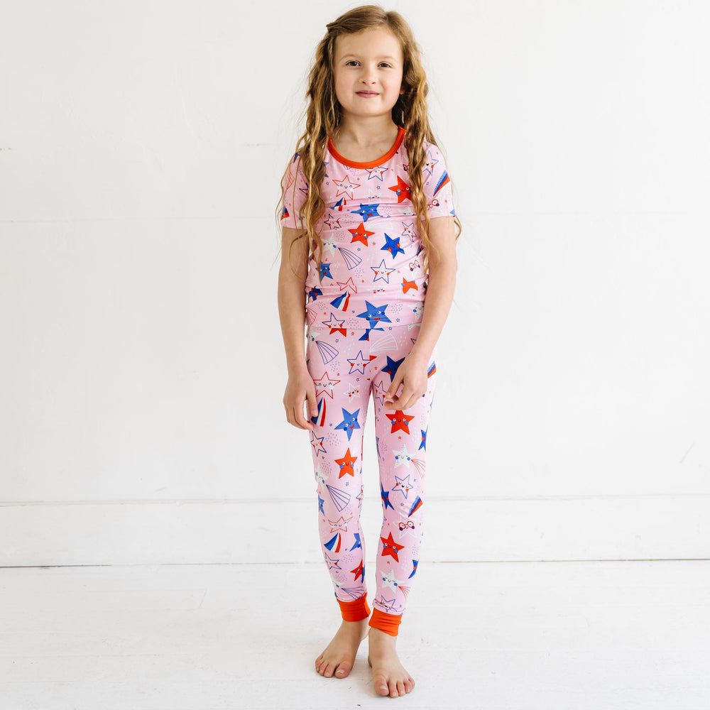 Child wearing a Pink Stars and Stripes printed short sleeve two piece pajama set