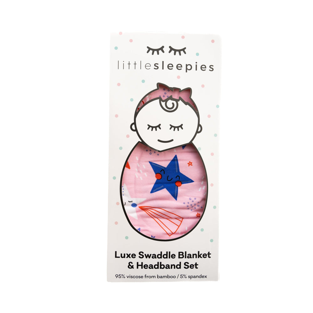 Flat lay image of Pink Stars and Stripes printed swaddle and headband set packaged in Little Sleepies peek-a-boo packaging