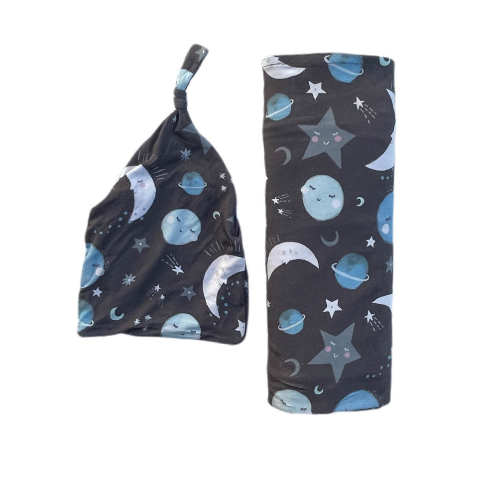 Click to see full screen - Flat lay image of Blue to the Moon and Back printed swaddle and hat set