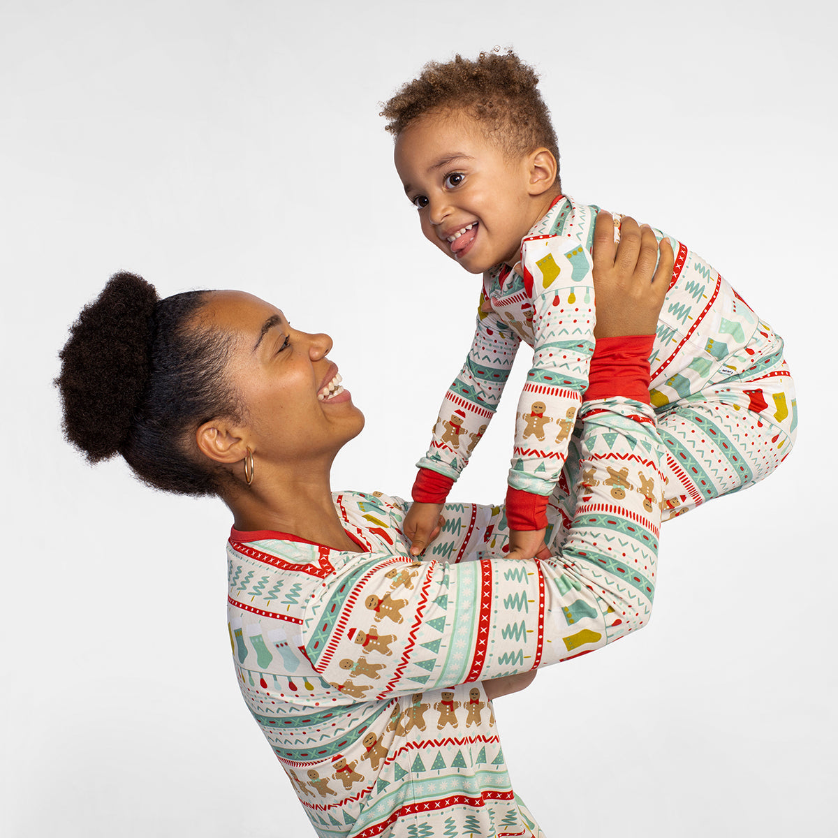 Mother is holding up her son wearing a women's Fair Isle pajama top. Her son is matching wearing a Fair Isle zippy