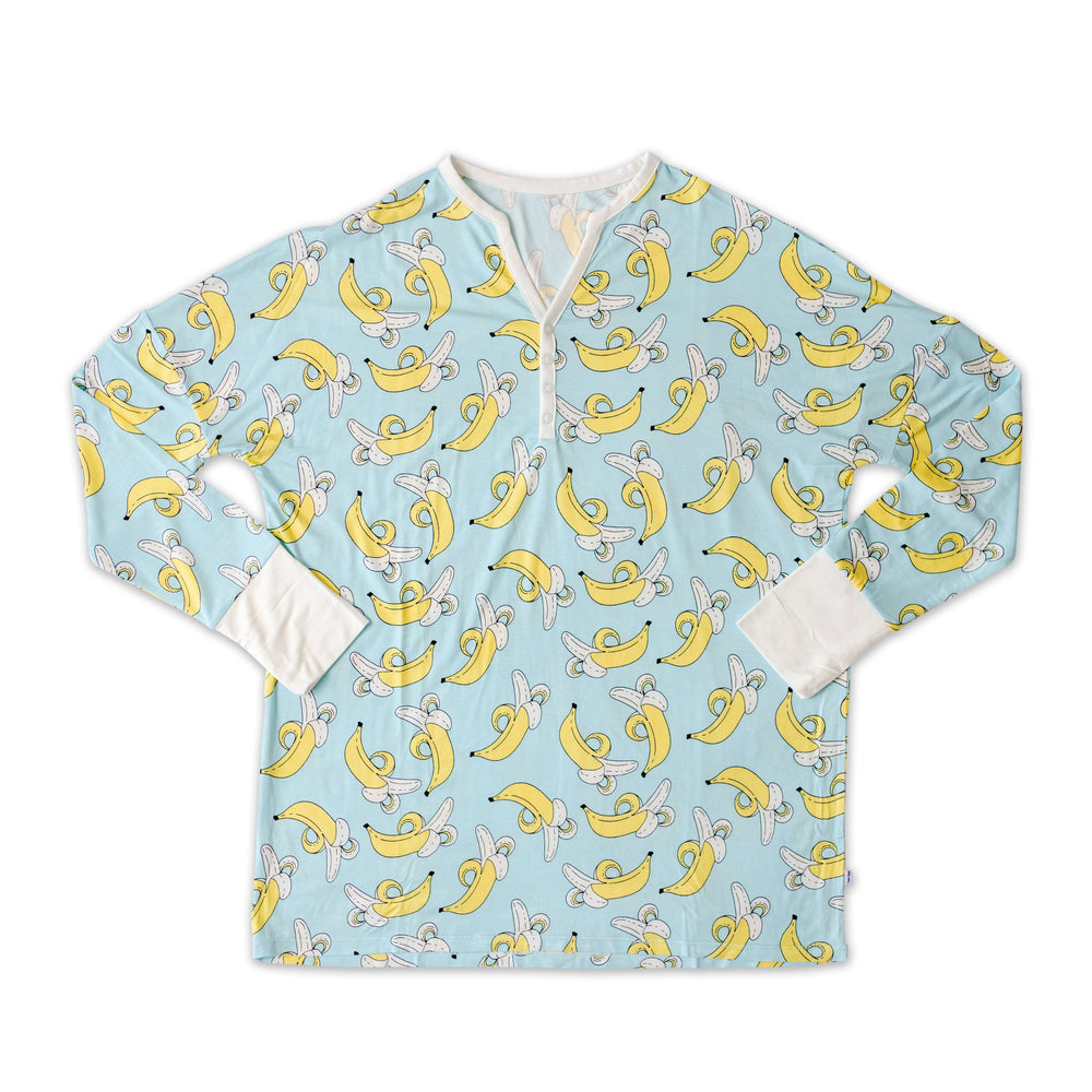 Flat lay photo of women's banana printed pajama top. This long sleeve top features a light blue background and pops of yellow with white trim accents on the collar and sleeve cuffs.