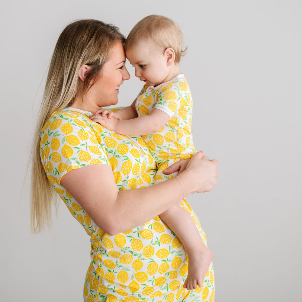 Woman holding her child wile wearing matching Lemons pajamas.