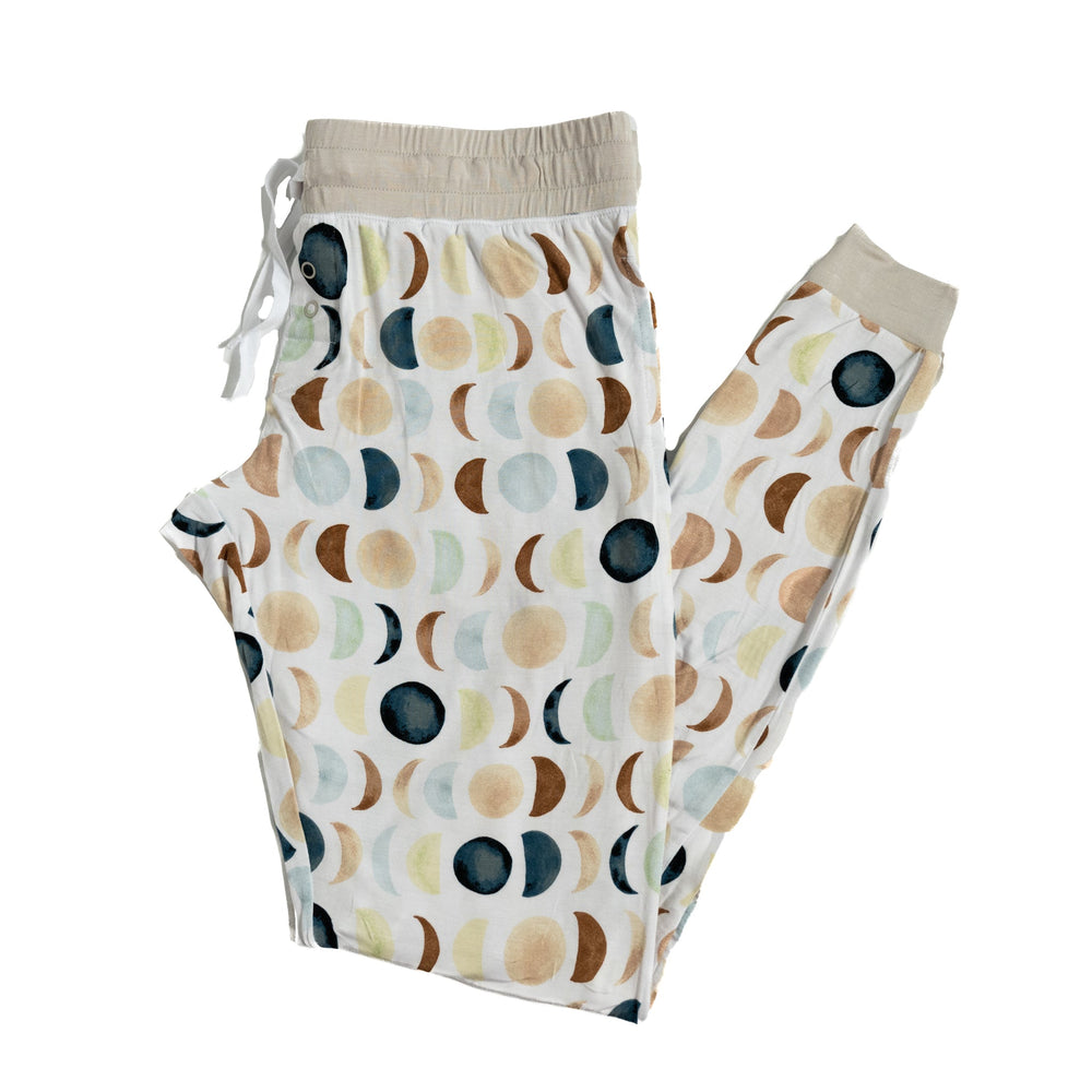 Flat lay image of women’s pajama pants in Luna Neutral print. This print features phases of the moon in the sweetest shades of creams, tans, and navy watercolor in an all over repeat pattern.