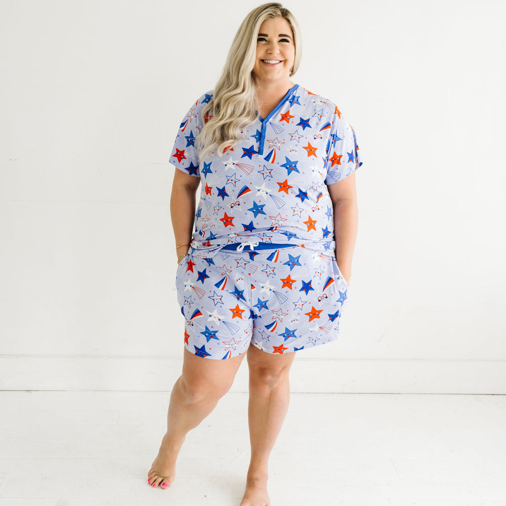 Woman wearing Blue Stars and Stripes printed women's pajama shorts and matching women's pajama top detailing the pockets