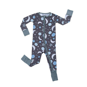 Flat lay image of long sleeve zip up romper in blue to the moon and back print. This print features blue and gray moons, stars, and planets on a charcoal background with dusty gray trim.