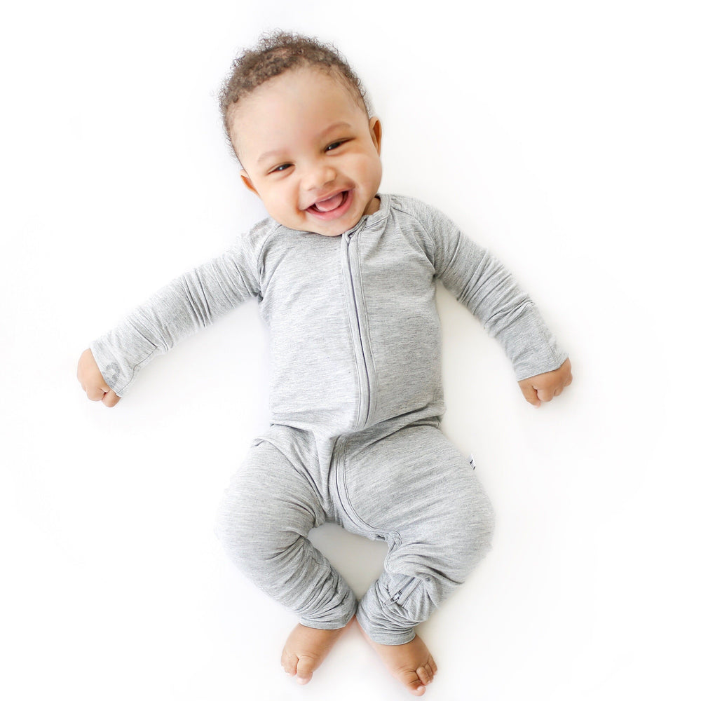 Image of baby boy wearing zip up romper in heather gray.