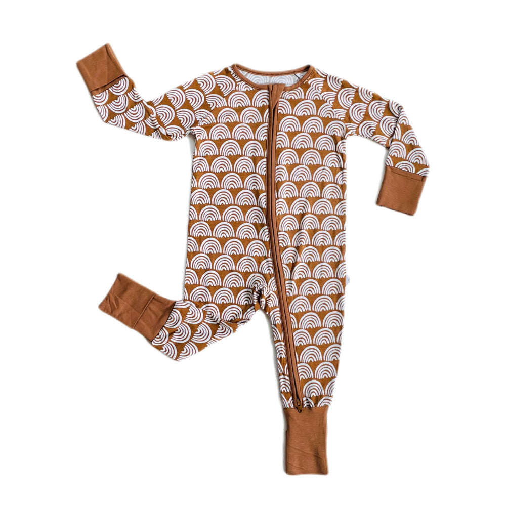 Flat lay image of long sleeve zip up romper in Rust Rainbows print. This print features white rainbows that sit upon a rust brown background with matching rust brown trim.